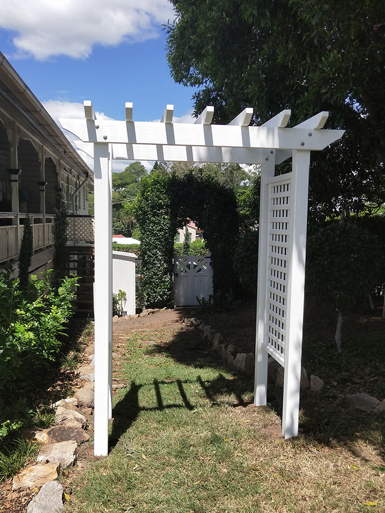 The white arbour creates a lovely frame and focal point for the pathway that leads down the side of the house.