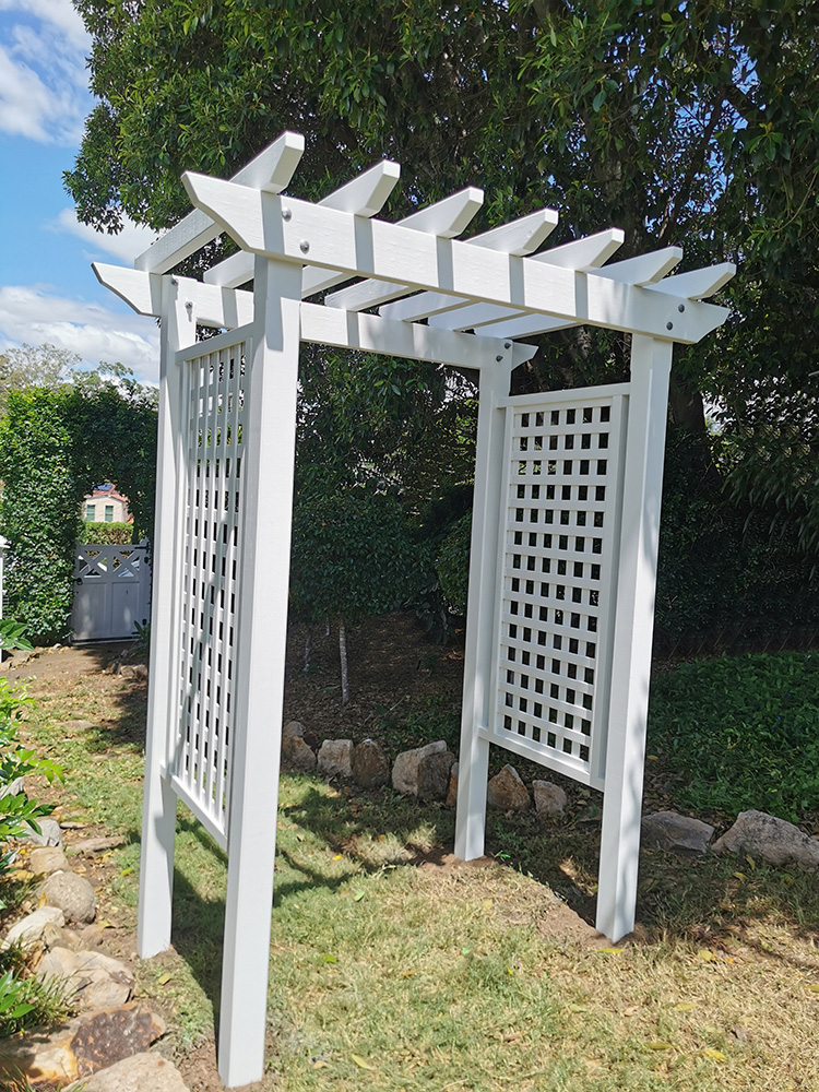 The white arbour looks lovely next to the gardens at the side of the house.