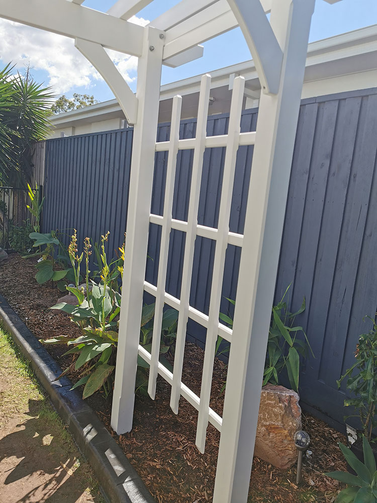 Screening has been added to the side of this Surfmist Painted Arbour so that flowering vines can climb and cover the Arbour.
