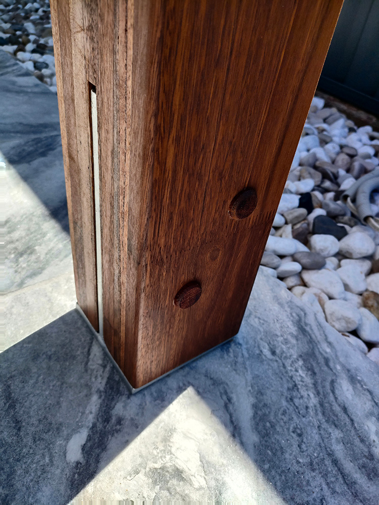 Laminated Spotted Gum Posts have been selected for this Pergola. We have carefully cut the post bases for a nice finish showing the knife plate slot and timber buttons on only one side of the posts.