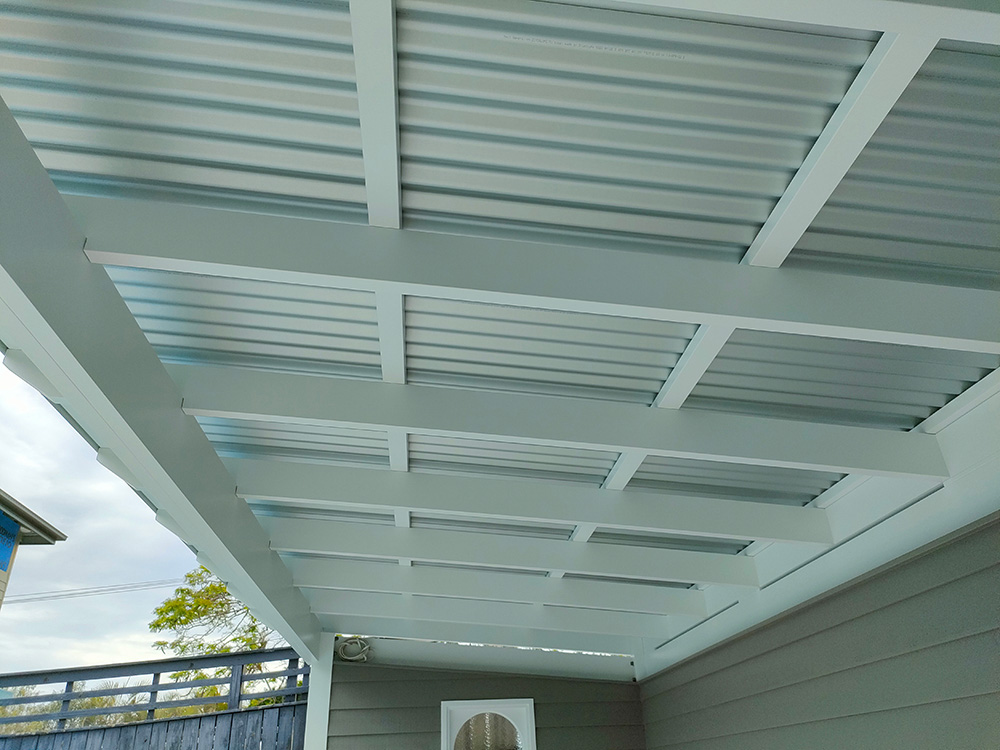 The colorbond metal roof looks great against the white exposed rafters of the Pergola style ceiling.