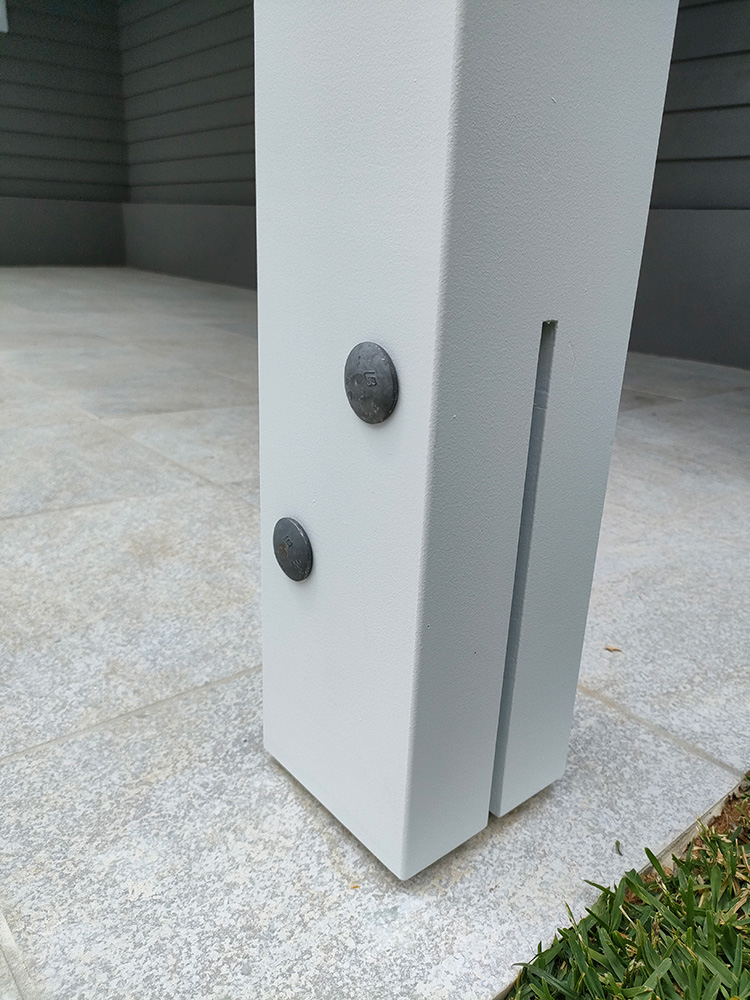 The laminated Pine posts have been precisely set onto the newly tiled pool surround. The Knife Plate or T Blade galvanized post bracket has been cut into post and cup head bolts have been used for a clean finish.