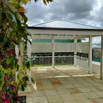 This painted Pine Gazebo includes 6 posts that frame the raised pool surround near the stairs. The new handrail provides a safe new area for the young family at this residence.