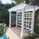 This white Pergola has many features including arched beams, screening and decorative boxes.