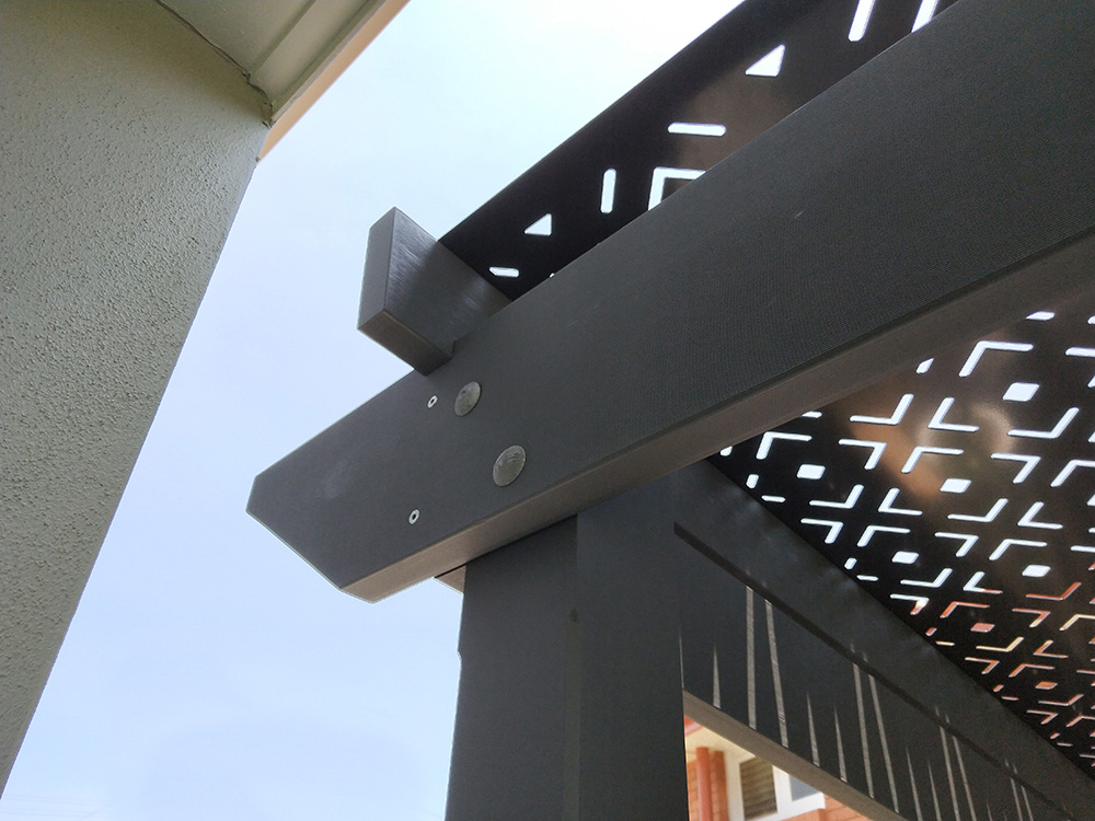 This pine pergola has a splayed profile selected with angled rafters so that it could be set in closely to the house.