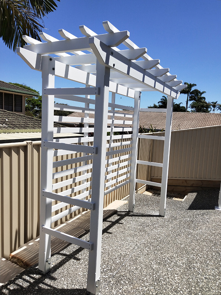 This painted white pergola is a new sitting area at the back of the residence. Once a flowering vine climbs the screening it will help add depth and aesthetics to the back yard.