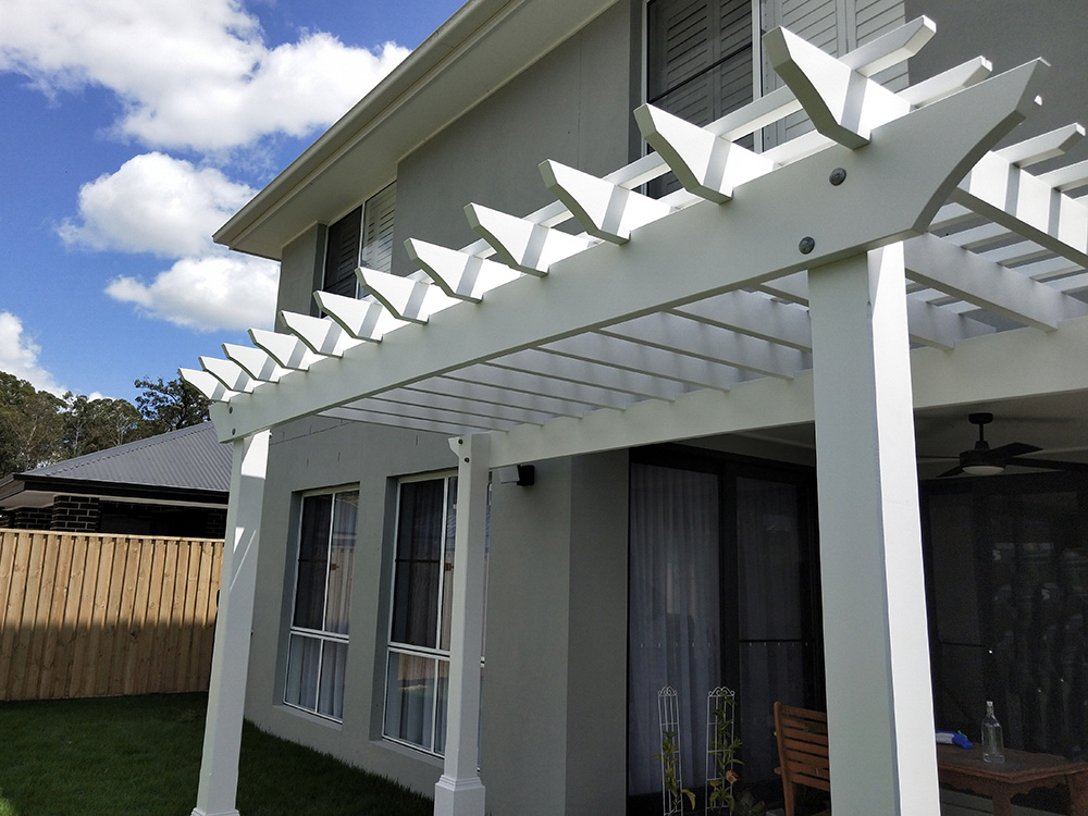This White Pergola has a slight arch in the beam which adds an additional touch of depth to the appearance from the back yard.