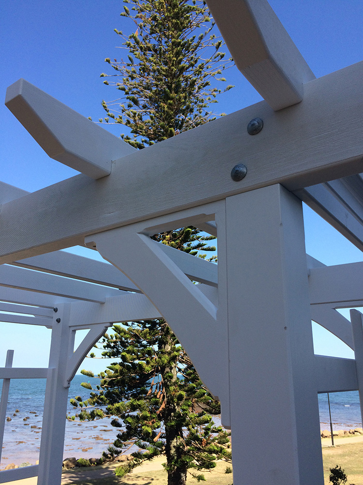 Knee Braces have been added to this white painted Pine arbour to provide strength and to soften the corners of the arbour.