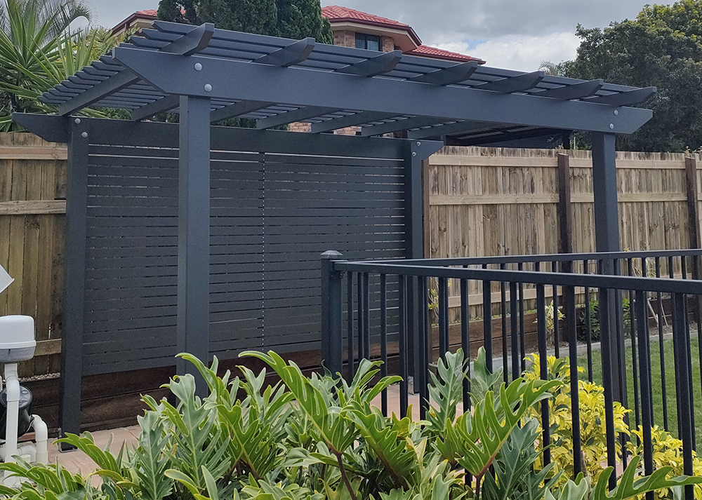 This Pergola Kit has been customized to adjust the size slightly, painted in Monument, add back screening and includes installation.