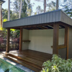 Hardwood Pool Cabana with walls and deck with stairs.