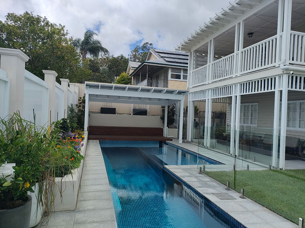 This Roofed Pergola is set at the end of the pool over top of the existing deck.