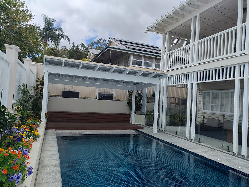 This Roofed Pergola is set at the end of the pool over top of the existing deck.