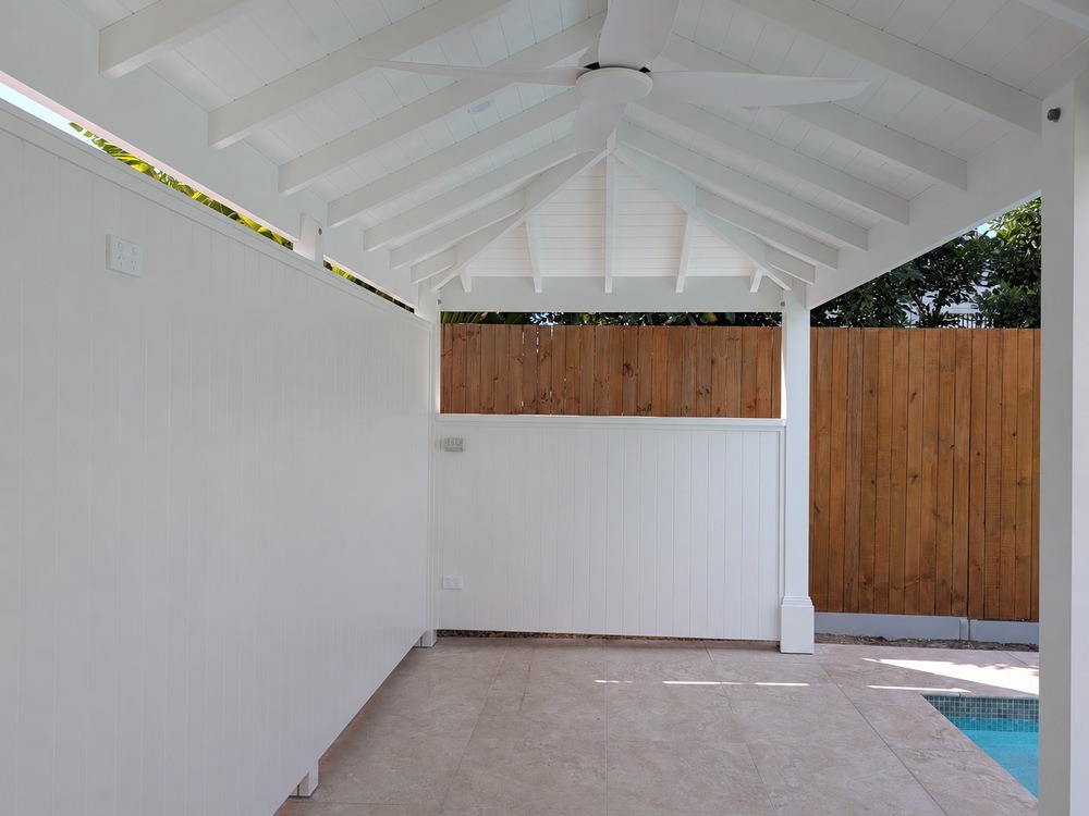 Interior of the Pool Cabana with a white VJ-lined ceiling, exposed painted timber rafters and half side wall.