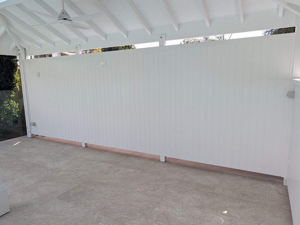 Full white VJ-lined rear wall beneath the Pool Cabana’s exposed painted rafters and VJ-lined ceiling.