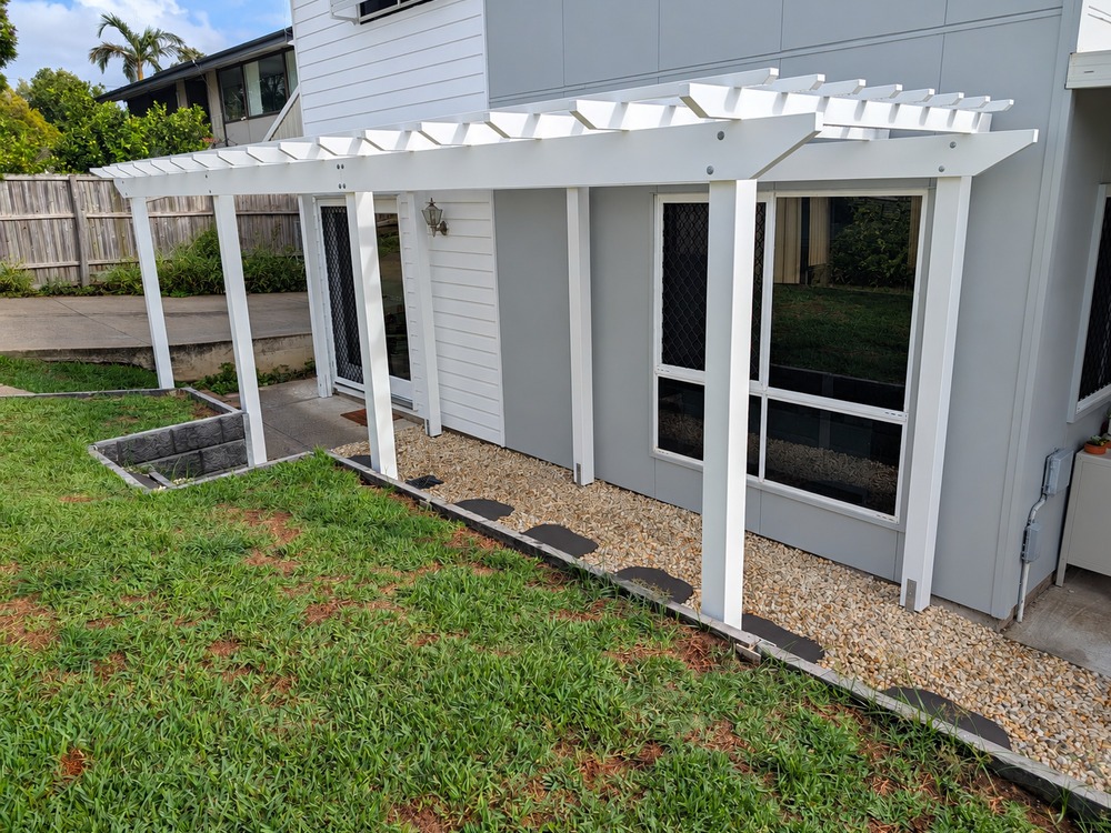 White Traditional Pergola viewed from the landscaped garden side of the house.