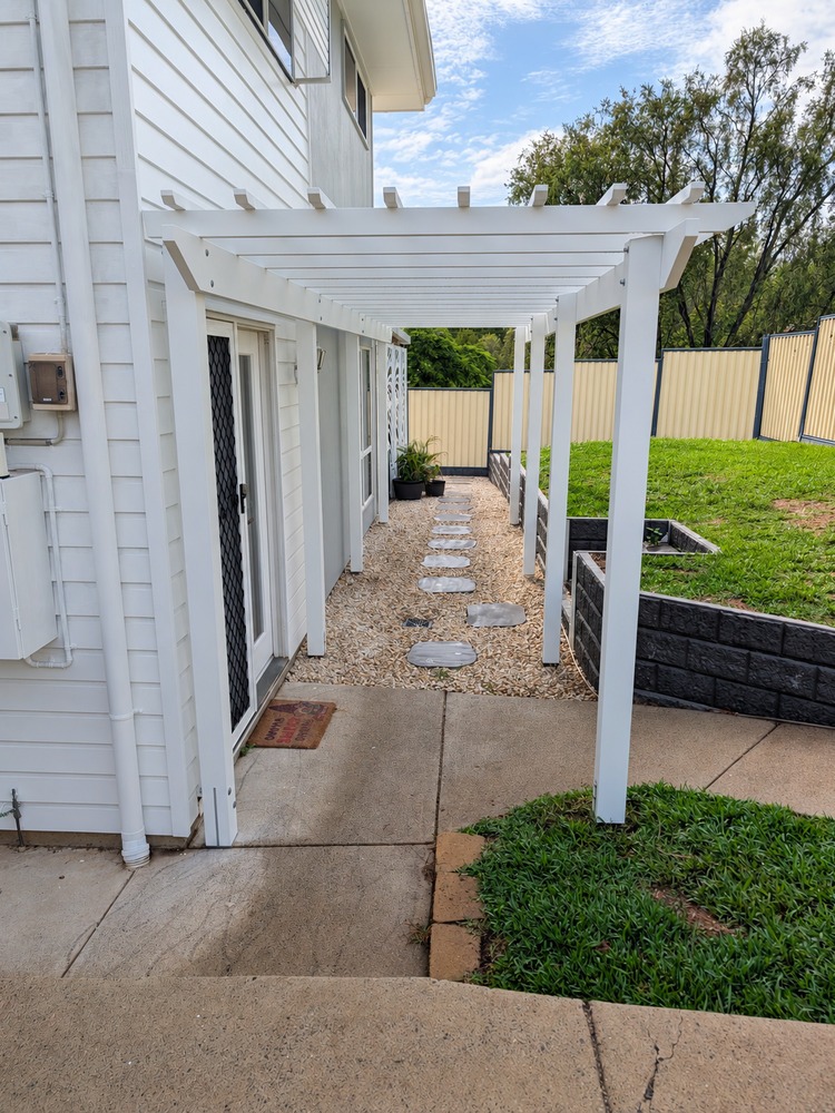 White traditional timber pergola over front entrance and walkway.