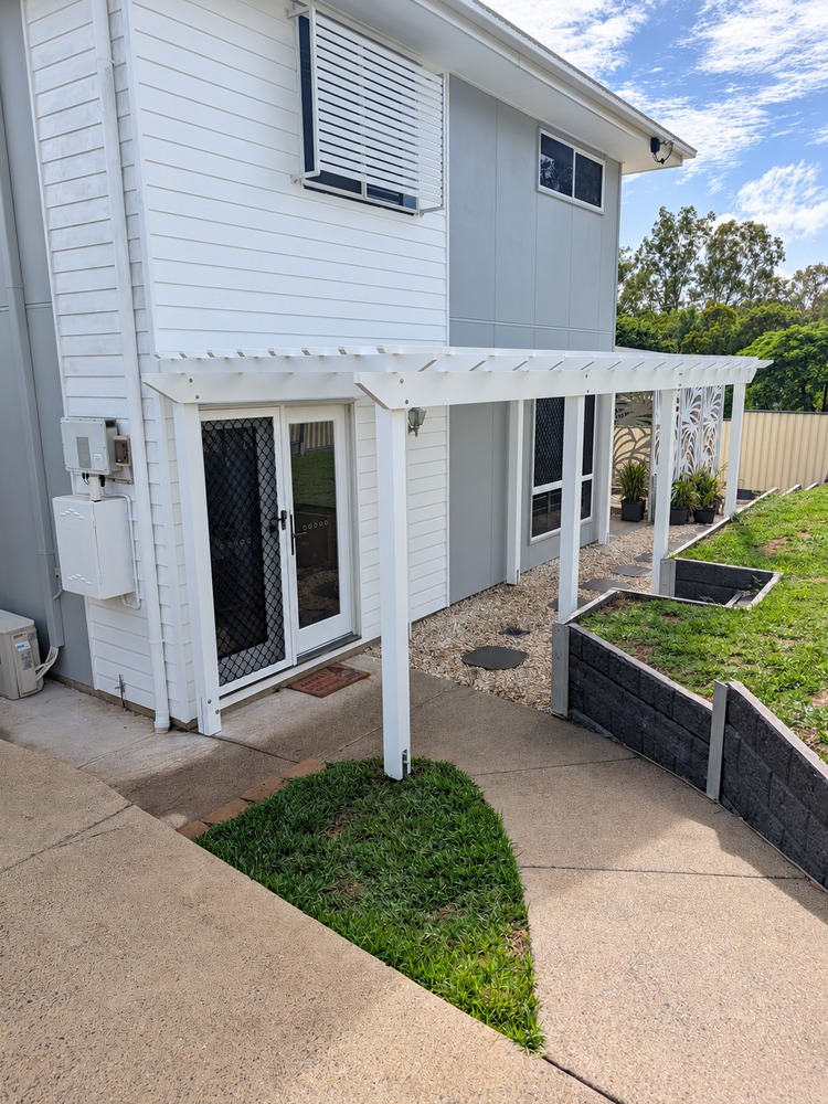 White Pine Pergola running along the house between the front entrance and alfresco area.