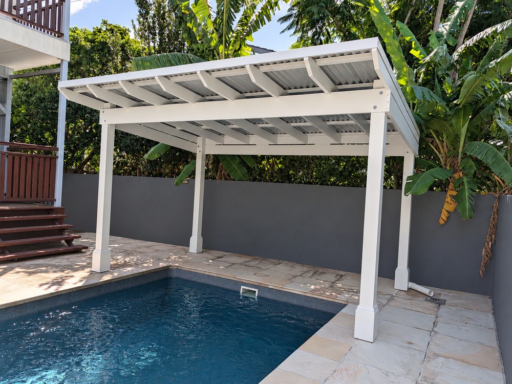 Angled view of the white Roofed Pergola beside the pool, showing exposed rafters and Decorative Post Boxes.
